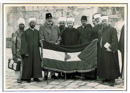 Hajj Amin (center) presenting Palestinian flag to Mawlana Shawkat Ali, (left of Hajj Amin) a leader of Indian Khilafat movement; next to Shawkat Ali is Shaykh Khwaja Nazir Hasan Ansari, 1931. © Ahmad al-Ansari.